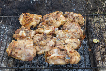 Closeup shot of chicken cooking on an outdoor grill