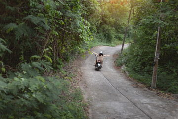 Couple riding a motorcycle on Sichang isle in Chonburi, Thailand.