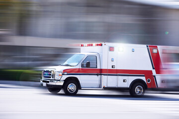 Blurred motion action view of an ambulance responding to the scene of an emergency. - obrazy, fototapety, plakaty