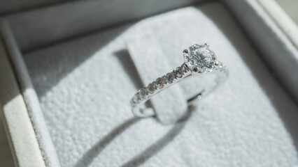 Close up of diamond ring with sunlight and shadow background. Love, valentine, relationship and...
