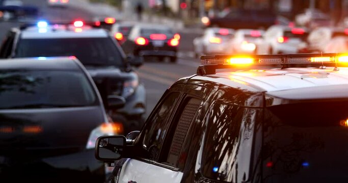Police units pull over a car on a city street.