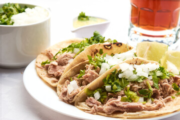 Pork or pork tacos, part that uses the knuckle and corn tortilla, prepared with xalapeño pepper sauce, cilantro and onion