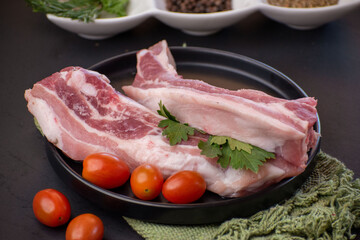 Pieces of raw pancetta pork with cherry tomatoes