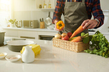 Cropped image of man choosing fresh ripe vegetables for dish he is cooking