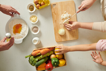 Hands of family cooking dinner, preparing ingredients, making dough, cutting onion