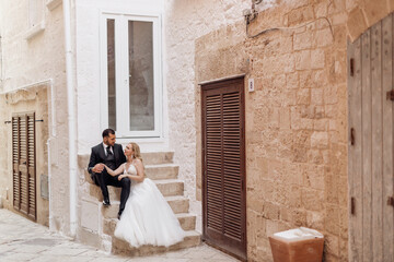 Two overdressed people, groom and bride, woman and man, just married. Hugging, sitting together,...