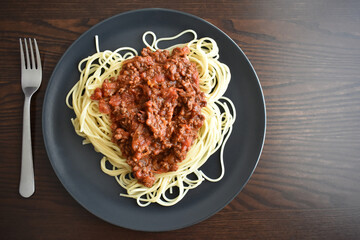 Spaghetti Bolognese with minced beef, onion, chopped tomato, garlic, olive oil, stock cube, tomato puree and Italian herb. Traditional Italian food on a plate.	
