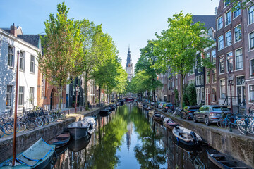 Boat on the canal, Amsterdam. Bicycles and cars on the street, traditional Netherlands house