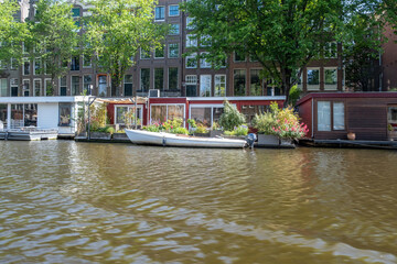 Fototapeta na wymiar Houseboat in canal, Amsterdam. Boat and traditional house brick façade, parked bikes. Netherlands.