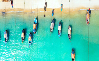 Aerial top view of the  local boat near the lagoon seashore as the tropical island in a coral reef...