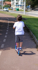 A child riding a scooter was photographed from behind