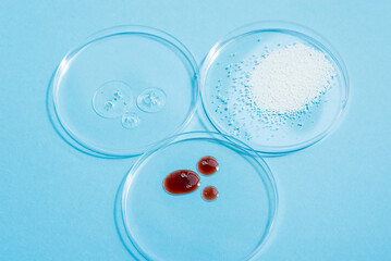 Cosmetic swatches. Appearance of the texture of the cream, red mask, foam and granules in petri dishes on a blue background. Natural skincare products. Beauty concept for face and body care