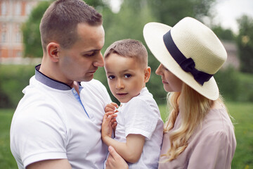 portrait family with a child a boy of 4 years old stand on green field in summer