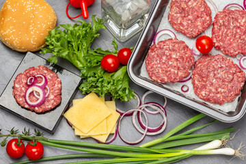 Green onions, cheese, water bottle. Buns with sesame seeds, green salad and tomatoes on table.