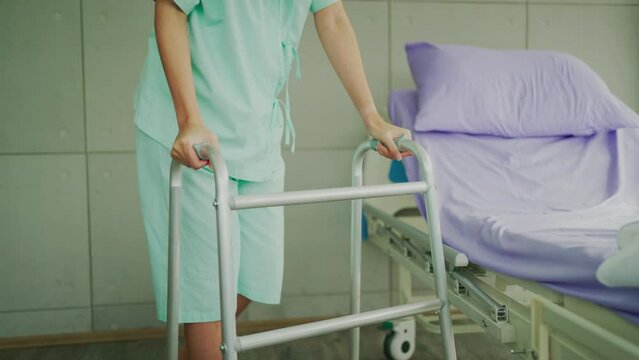 patient woman using a walker for balance waling after recovery in the hospital, Knee and leg problem, Medical Insurance concept
