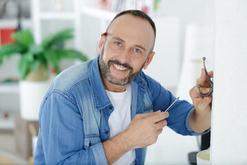 portrait of man mounting a coat hook on the wall