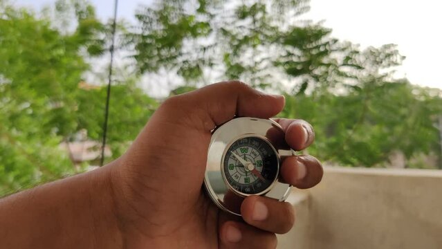 Footage of a compass made of metal shot against blur background in summers during daylight used for directions by travelers