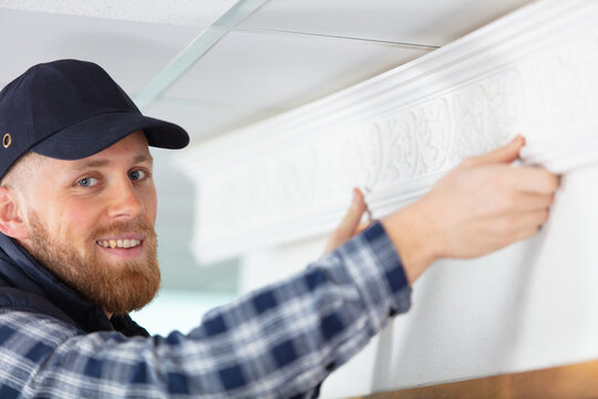 Man Is Installing The Baseboard Repair Works Indoors