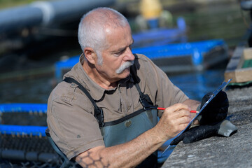 portrait of fish farm worker with clipboard
