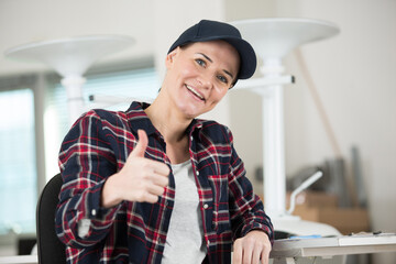 happy female carpenter showing thumbs up