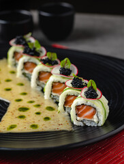 Sushi set of various products on a black stone plate. Blur background and selective focus