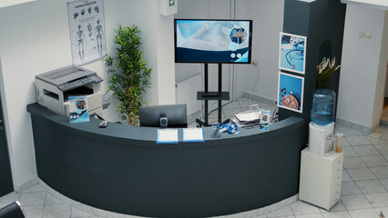 No people at hospital reception desk with counter in lobby to help with appointments and checkup visits from patients. Waiting room area with seats inside, modern emergency space at clinic.