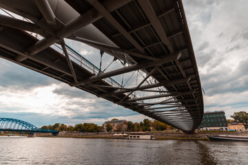 A view from the banks of the Vistula River that flows in Krakow, over the ancient bridge above it and the river water
