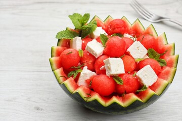 Watermelon Feta salad in watermelon basket with white wood table background.Fresh and healthy...