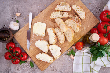 pieces of sliced baguette with spread butter on wooden board