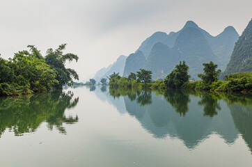 landscape with the Yulong river and limestone mountains in hazy weather, Yangshuo, Quangxi province, China