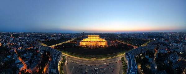 Aerial drone panoramic view of Palace of the Parliament in Bucharest downtown at night, Romania