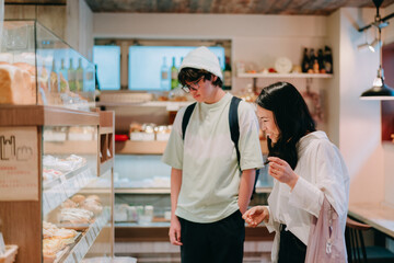 Fototapeta na wymiar 小さなパン屋でパンを買う母親と10代の息子
