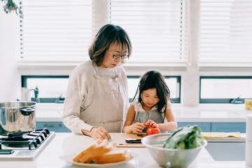 祖母から料理を習う女の子