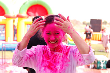 Young Indian lady With Colored Face celebrating festival of colors known as holi