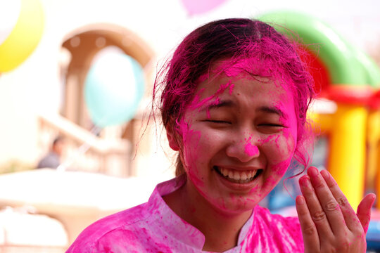 Young Indian Women With Colored Face celebrating festival of colors known as holi