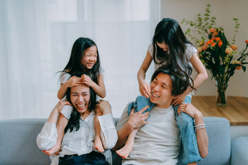 ソファに座って肩車をしてもらう子供達と両親