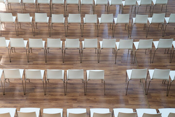 several rows of neatly arranged chairs with one chair missing
