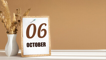 october 6. 6th day of month, calendar date.White vase with dead wood next to cork board with numbers. White-beige background with striped shadow. Concept of day of year, time planner, autumn month