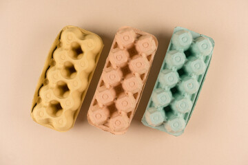 Pulp egg cartons made with pulp and straw over light brown background. Eco friendly egg boxes,...