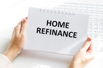 HOME REFINANCE white paper notepad in human hands, business concept