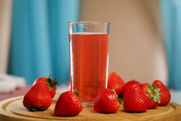 Fresh delicious strawberry juice pours into a glass. Healthy antioxidant juice with vitamin from ripe fruits