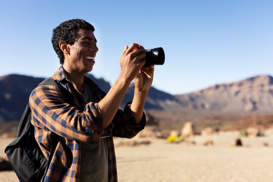 Young man taking pictures on a road trip. Man making memories on the mountain.