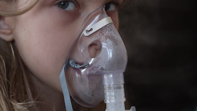 home environment. a girl with white hair is breathing through a medical mask. inhaler for cough and respiratory relief