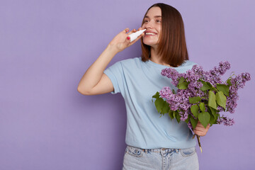 Image of young Caucasian woman dresses blue casual style t shirt using nasal spray, being satisfied...