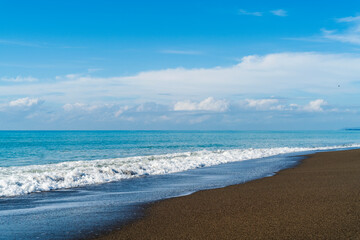 Fototapeta na wymiar A beach with brown sand and blue skies