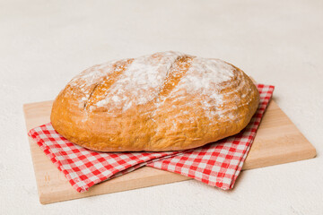 Freshly baked bread on cutting board against white wooden background. perspective view bread with copy space