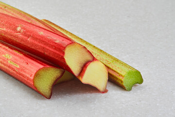 Stems of ripe rhubarb on a gray background, close-up, selective focus, ingredients for making traditional pies
