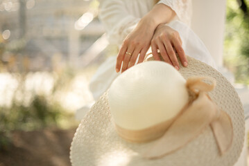 Close up  straw hat holded by young woman in her hand, summer outdoor lifestyle outfit