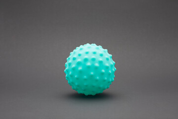 Green spiky massage ball on black background