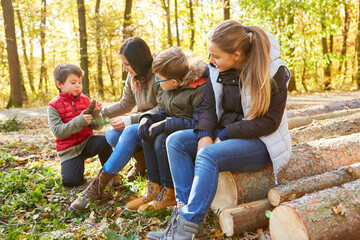 Lehrerin und Kinder Gruppe im Wald bei der Baumkunde